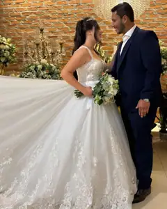 Noivos de mãos dadas no salão, vestido com cauda longa